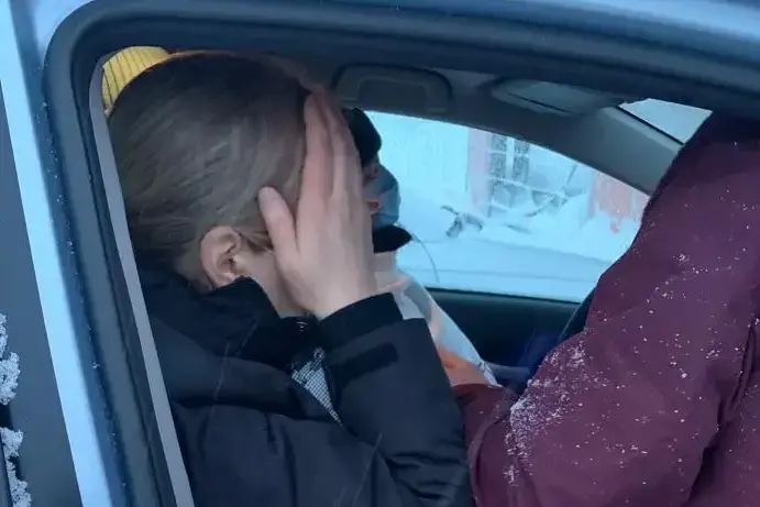 Henkilö autossa pitelee päätään kädellään onnettomuustilanteessa.