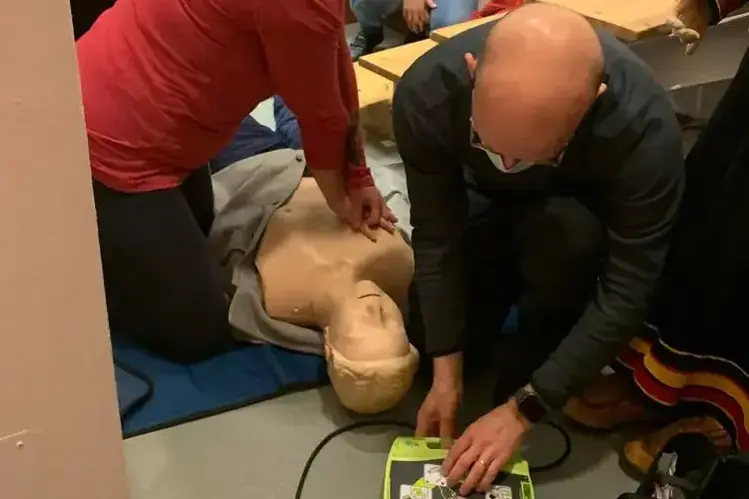 Henkilö suorittaa elvytystä harjoitusnukelle sydäniskurin avulla.