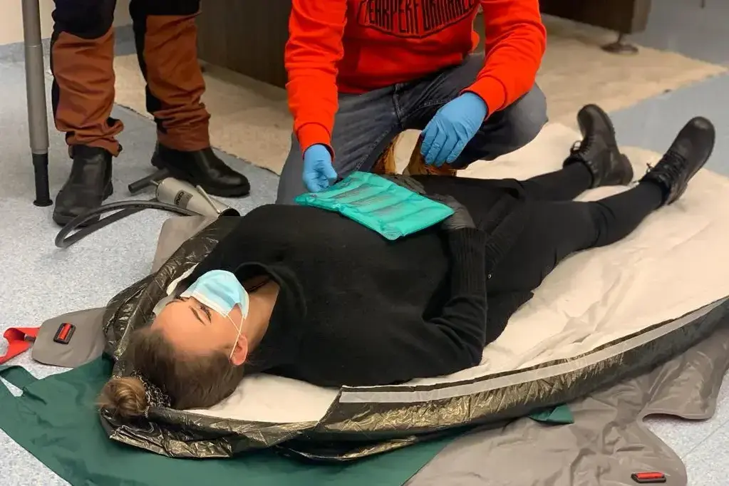 Ensiapuharjoitus, jossa henkilölle suoritetaan tarkastusta harjoitustilanteessa.